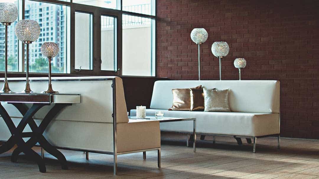 cream leather couches with brown brick feature wall