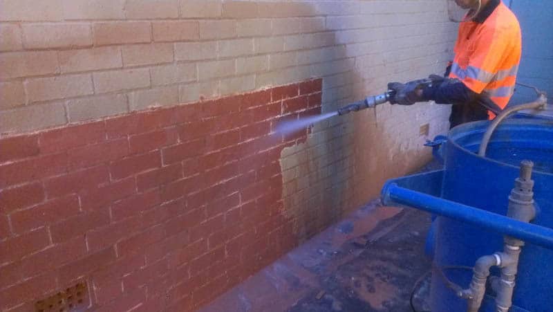 Sandblasting paint off a brick wall